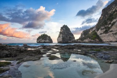 Endonezya 'daki Bali Adası. Elmas plajı, Nusa Penida. Turkuaz okyanus ve dağlar. Gün batımı manzarası. Duvar kağıdı arka planı. Doğal bir manzara. Romantik rahatlama yeri.