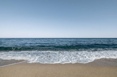 Deniz Burnu. Dalgalı deniz. Çakıl taşlarıyla kaplı güneşli bir sahil. Gökyüzü açık. Yaz turist havuzu mevsimi. Duvar kağıdı arka planı. Doğal manzara..