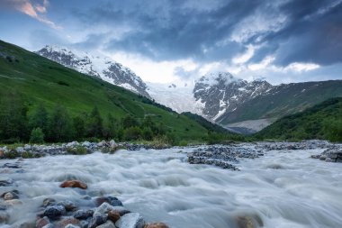 Nehirden shore taşlar ile kaplı, fantastik buzul ve dik kayalık dağlar karla kaplı yeşil çayırlar açılır. Mutlu bir yaşam tarzı. Güzel evren.