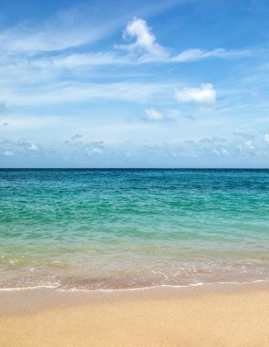 Dikey deniz manzarası. Kumsallı güneşli bir gün. Mavi gökyüzü ve dalgalar. Yaz tatili. Duvar kağıdı arka planı. Doğal bir manzara. Sıcak sahillerde romantik bir tatil..