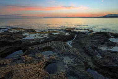 Günbatımı tropikal manzara. Taş plajda yaz denizi. Duvar kağıdı arka planı. Doğal bir manzara. Romantik rahatlama yeri. Türkiye 'nin Antalya tatil beldesi.