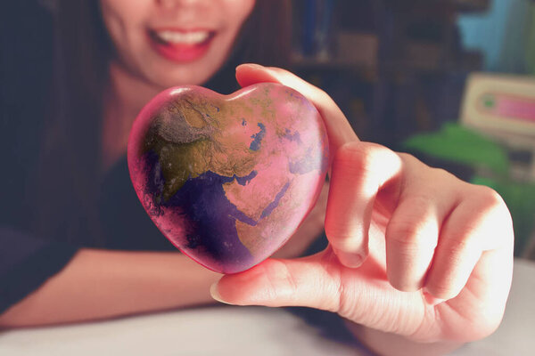 У девочки в руке мир в форме сердца. Мировой протекционизм.