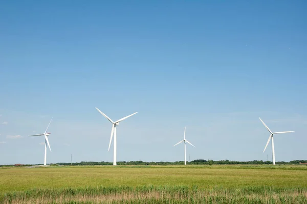 Windräder Erzeugen Strom Auf Der Grünen Wiese Stockbild