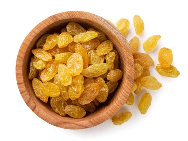 Tahta bir tabakta sarı kuru üzümler ve beyaz bir zemine yakın plan serpiştirilmiş. Üst görünüm