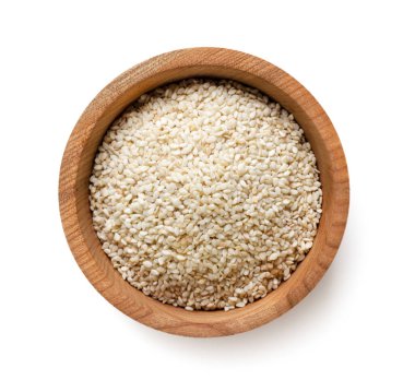 Tahta bir tabakta susam, beyaz arka planda yakın plan. Üst görünüm