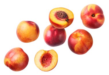 Olgun nektarinler ve yarımlar beyaz arka planda yakın planda uçarlar. İzole edilmiş