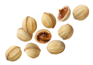 Fındık ve yarım şeklinde kurabiyeler beyaz arka planda yakın planda uçar. İzole edilmiş