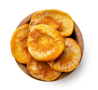 Beyaz arka planda, ahşap bir tabakta kurutulmuş şeftali. Üst görünüm