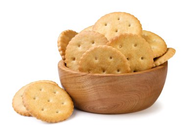 Tahta bir tabakta yuvarlak krakerler ve beyaz bir arka plana yakın plan serpiştirilmiş. İzole edilmiş