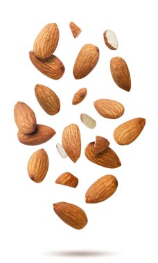 Badem taneleri ve parçalar beyaz arka planda yakın planda uçuyor. İzole edilmiş