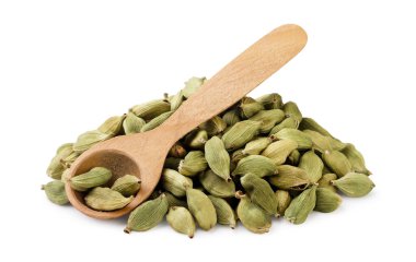 Bir yığın kurutulmuş kakule ve tahta kaşıkla beyaz üzerine yakın plan. İzole edilmiş