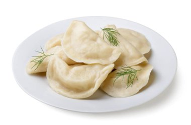 Kaynamış hamur köfteleri ve dereotu yaprakları beyaz arka planda yakın plan bir tabakta. İzole edilmiş