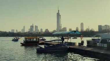 Çin 'in Jiangsu kentindeki Nanjing şehrinde şehir binaları ve teknesi olan Xuanwu Gölü.