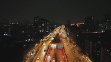 Çin 'in Jiangsu şehrinde gece vakti Nanjing şehrinde sokak trafiği olan şehir binalarının hava görüntüsü.