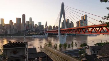Chongqing şehrinin kentsel mimari manzarası ve Çin 'de gün batımından batımına kadar nehir üzerinde köprü.