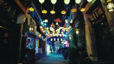 HANGZHOU, ÇİN 2, 2021: Geceleri dükkanlar ve restoranlarla sokak manzarası