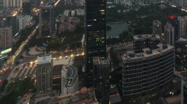 Çin 'in Guangdong kentindeki sisli bir günde, gün batımından akşama kadar kentsel gökdelen binalarının zamansız manzarası..