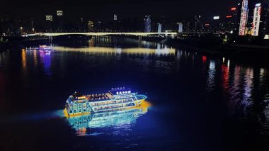 Çin 'de Chongqing' de gece vakti nehirde renkli bir tekne.