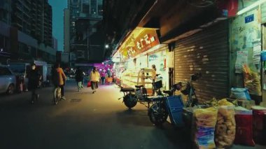 GuANGZHOU, ÇİN 2, 2021: Mağazaları ve yayaları olan şehir sokak manzarası