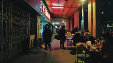 GuANGZHOU, ÇİN 2, 2021: Mağazaları ve yayaları olan şehir sokak manzarası