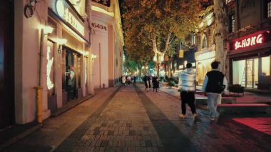 HANGZHOU, ÇİN 2, 2021: Geceleri dükkanlar ve restoranlarla sokak manzarası