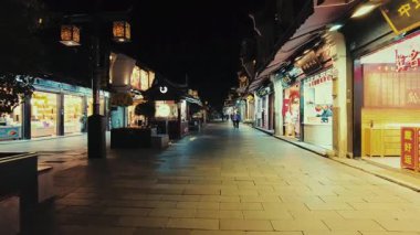 HANGZHOU, ÇİN 2, 2021: Geceleri dükkanlar ve restoranlarla sokak manzarası
