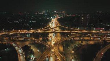 Çin 'in Jiangsu şehrinde gece vakti Nanjing şehrinde sokak trafiği olan şehir binalarının hava görüntüsü.