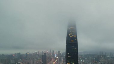 Çin 'in Guangdong kentindeki sisli bir günde, gün batımından akşama kadar kentsel gökdelen binalarının zamansız manzarası..