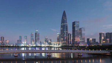 Gündoğumunda Çin 'in Guangdong kentindeki Shenzhen şehrinde göl üzerindeki kentsel gökdelen binalarının zamanaşımı manzarası.