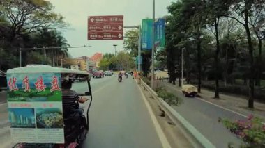 XISHUANGBANNA, YUNNAN, ÇİN 2, 2021: Trafik ve mağazalarla şehir manzarası