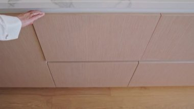 Mutfaktaki kişi çekmeceyi açar.