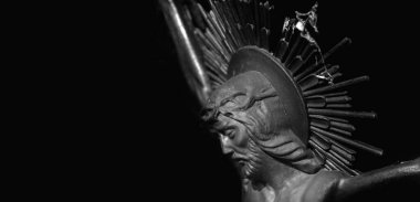 İsa 'nın çarmıha gerilmesi siyah arka plana karşı. Antik ahşap bir heykel. Siyah beyaz görüntü. Metin için alanı kopyala.