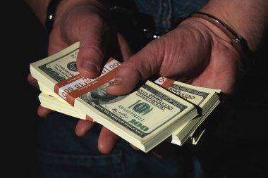 Yolsuzluk, yasadışı bahşiş konsepti. Yakından tutuklanmış, elleri kelepçeli bir adam..