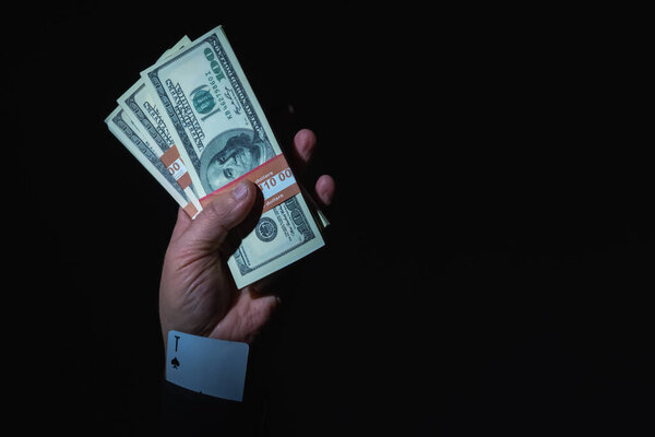 Бизнесмен со скрытой картой в рукаве как символ мошенничества и нечестных игр (бизнес, мошенничество, прибыль, преступность, понятие отмывания денег). Копирование пространства.