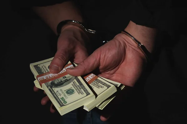 Zamknij Aresztowanego Człowieka Trzymającego Pieniądze Kajdankach Czarnym Tle Jako Symbol — Zdjęcie stockowe
