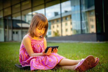 Psychological problems of lack of children's communication, socialisation and gadget mobile addiction of young people. Young beautiful child girl holding mobile phone.