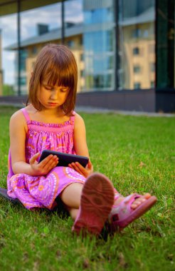 Little girl with phone. Psychological problems of lack of children's communication, socialisation and gadget mobile addiction of young people. Vertical image.