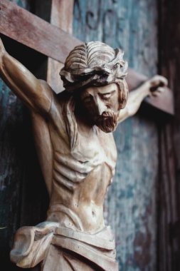 Jesus Christ crucified. Closeup an ancient wooden statue. Vertical image. 