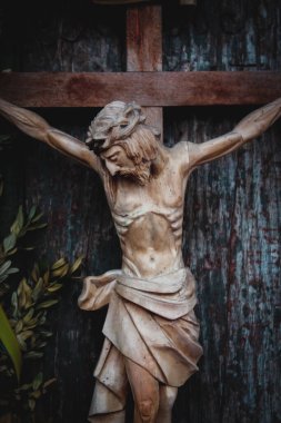 Jesus Christ crucified. Close up an ancient wooden statue. Vertical image