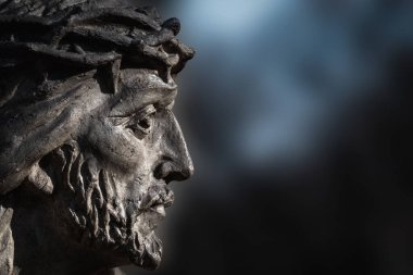 Fragment of antique stone statue Jesus Christ in a crown of thorns as symbol of love, faith and religion. Copy space for text. Close up.