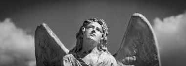 Angel. Fragment of ancient stone statue. Horizontal black and white image.