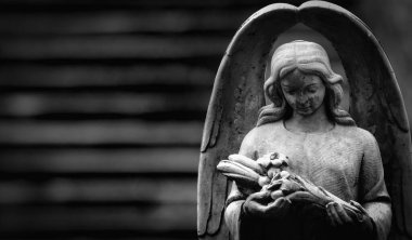 Death. Beautiful angel as symbol of pain, fear and end of life. Ancient stone statue. Black and white image. Copy space for text or design.
