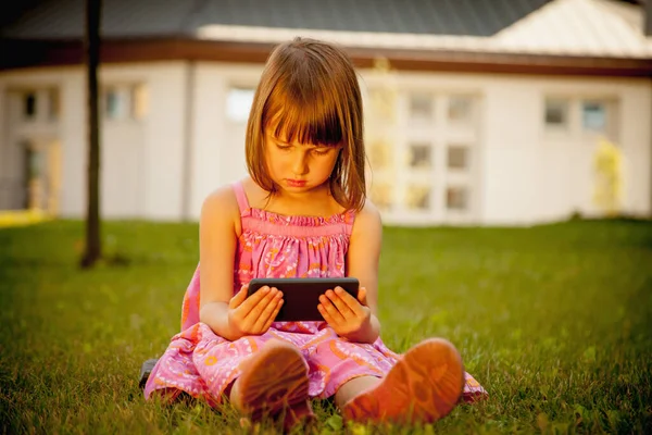 Psychological problems of lack of children\'s communication, socialisation and gadget mobile addiction of young people. Young beautiful child girl holding mobile phone. Horizontal image.