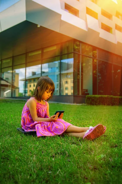 Portrait of little girl with phone. Psychological problems of lack of children\'s communication, socialisation and gadget mobile addiction of young people. Vertical image.