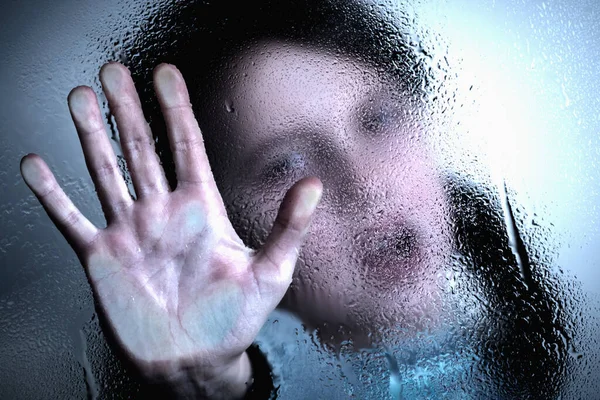Violence, abuse, school bullying, body language concept. Portrait of beautiful female kid standing behind wet glass  and doing stop gesture.