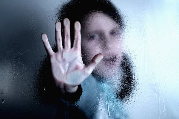 Portrait of young girl with a raised hand making a stop sign gesture. Violence, harassment and child abuse prevention concept.