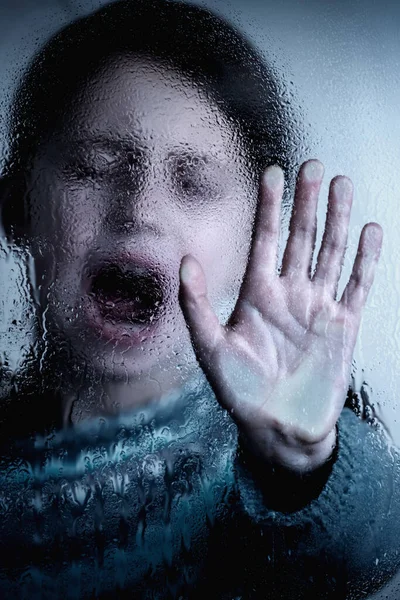 Dramatic portrait of young child girl showing STOP gesture with her hand. Concept of domestic violence and child abuse. 