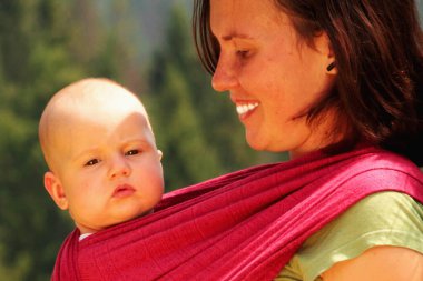 Anne ve çocuğu açık havada asılıydı. Anne ve bebek güneşli ışıklarda eğleniyorlar. Aile birlikte eğleniyor. Mutlu çocukluk kavramı. 