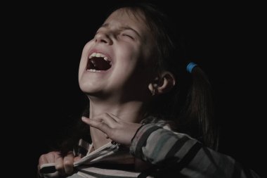 Kavramsal görüntü: çocuklarda acı. Gergin ve aşırı heyecanlı genç kızın psikolojik portresi çığlık atıyor ve tişörtü yırtmak istiyor..