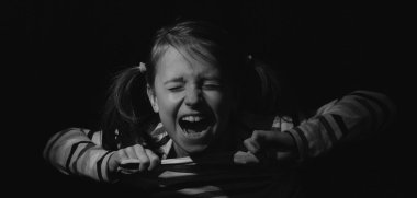 Kayıp çocukluk, acı, akıl sağlığı, stres, psikoloji, depresyon, panik ataklar ve çocuklarda endişe. Çocuk silueti siyah arka planda çığlık atıyor.